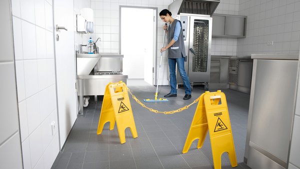 Warnschilder während der Reinigung eines Küchenbodens